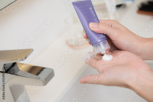 Fototapeta Naklejka Na Ścianę i Meble -  Close up of women applying body lotion cream on hand.
