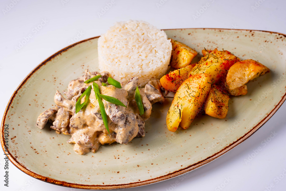 mushrooms in sauce with potatoes and rice on a white background mushrooms in sauce with potatoes and rice on a white background