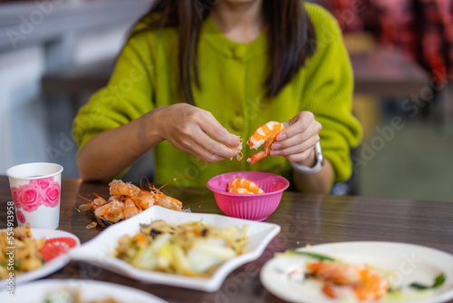 Woman peel off shrimp at restaurant