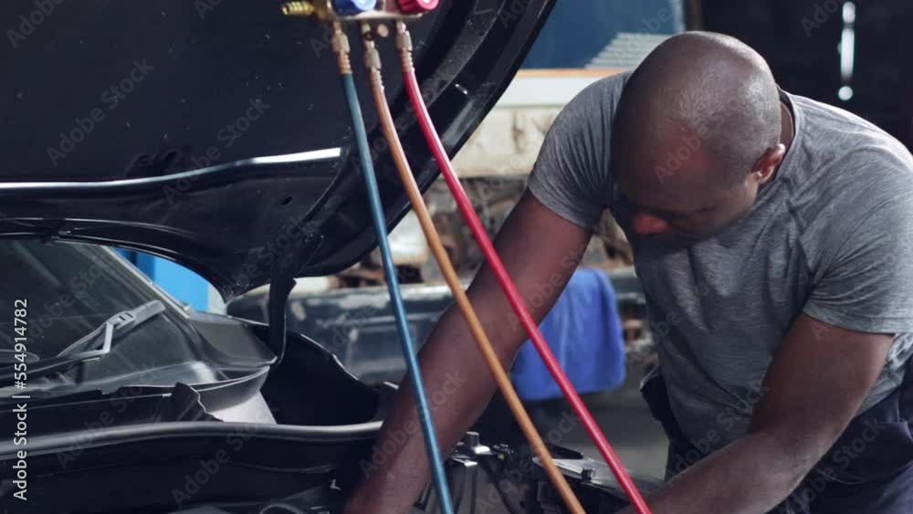 Car air conditioner check and service. Meter measuring equipment for filling air conditioners. Black mechanic man Check car air conditioning system refrigerant recharge