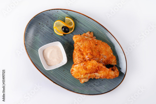 fried fish with garlic sauce, served in a restaurant, on a white background