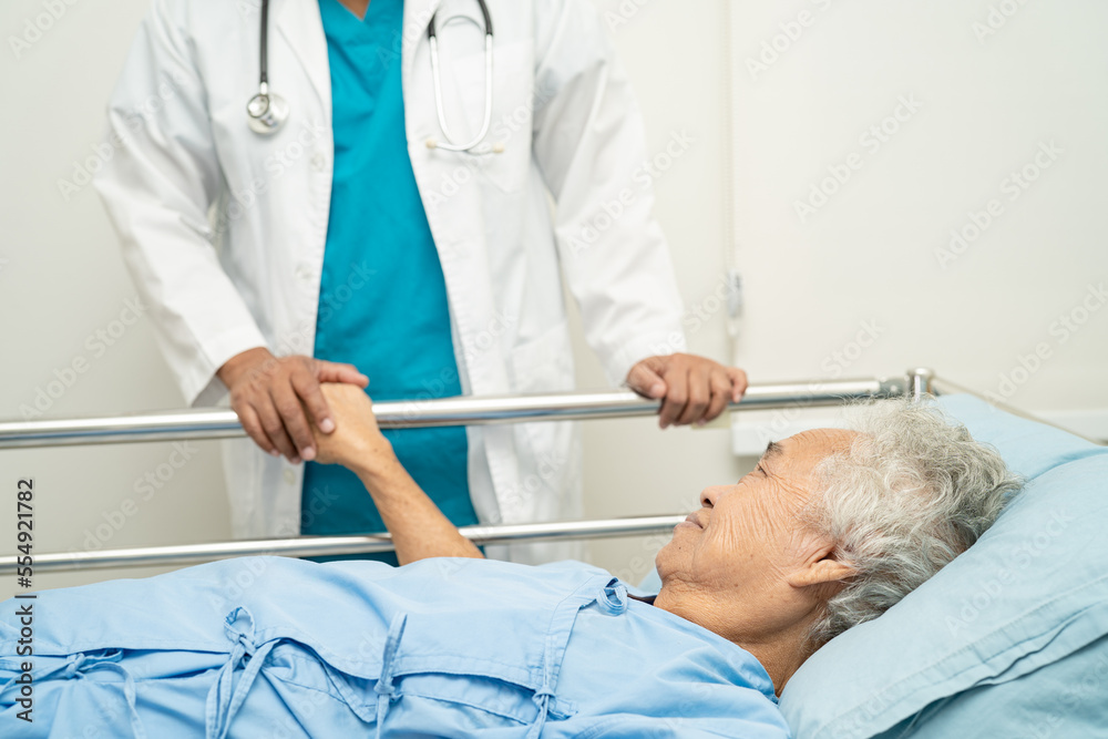 Obraz premium Doctor touching hands Asian senior or elderly old lady woman patient with love, care, encourage and empathy at hospital.
