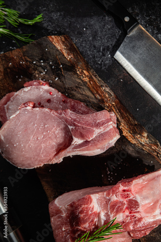 Raw pork steak on the bone on a wooden table. Cooking meat