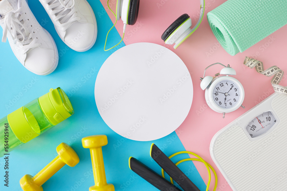 Active living concept. Creative layout made of fitness accessories on pastel pink and blue background with card note in the middle. Flat lay. Minimal sport idea.