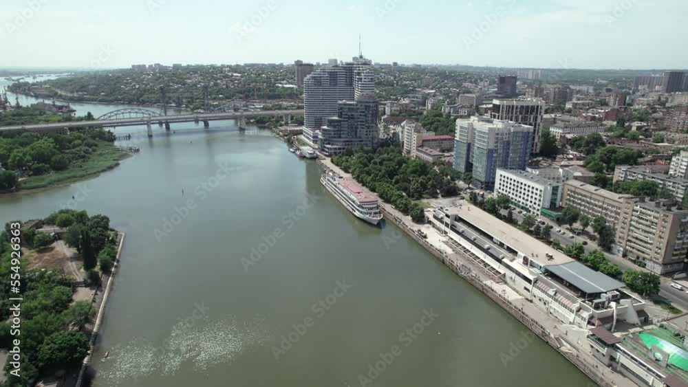 Aerial view of vessels moored to quay, residential buildings and bridge. Panoramic aerial view of riverside city Aerial view of vessels moored to quay, residential buildings and bridge. Panoramic aerial view of riverside city