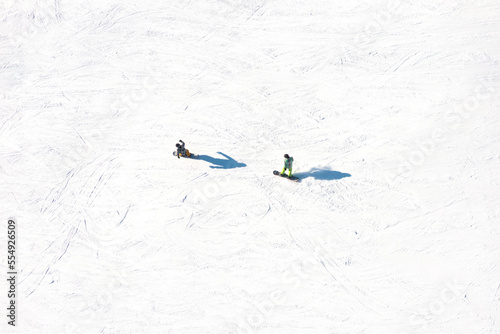 Ski resort. An aerial view of the snowboarding team. Winter sports. Snow slope in the mountains for sports. Group training. Exercise with friends. Winter landscape from a drone. photo