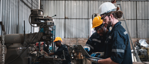 Industrial engineers inspect and perform maintenance on the machines at factory machines.