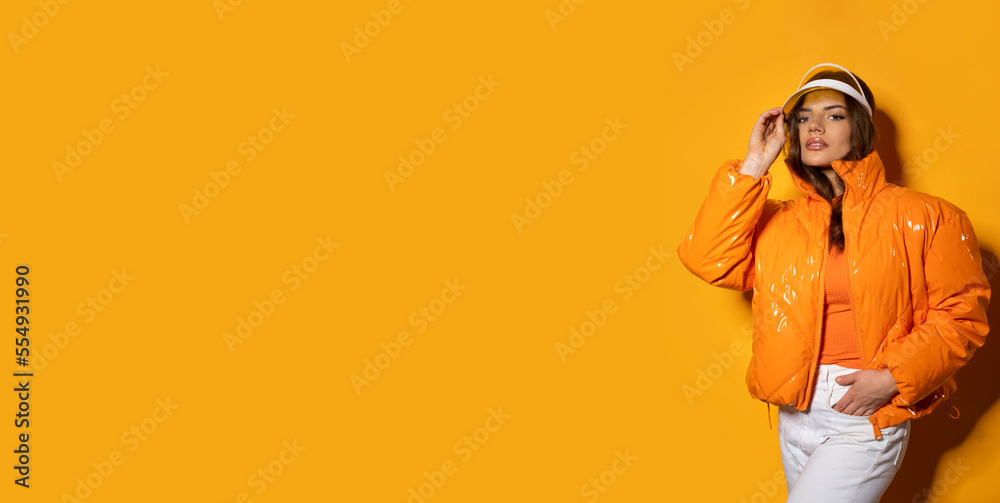 Beauty latino female with hood and jacket on orange background with shadow. Beauty latino female with hood and jacket on orange background with shadow.