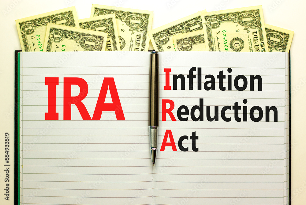 IRA inflation reduction act symbol. Concept words IRA inflation reduction act on white note on a beautiful background from dollar bills. Business IRA inflation reduction act concept. Copy space.