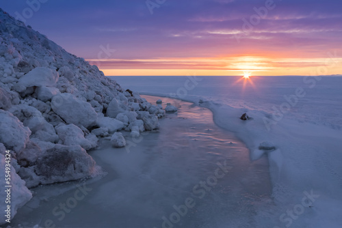 Winter sunset over the ice river and the ice covered Kotzebue Sound; Kotzebue, Alaska, USA photo