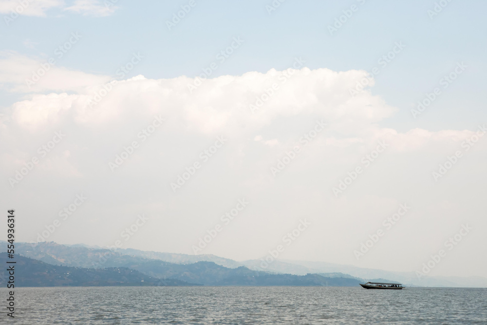 A boat full of tourists cruises along Lake Kivu.; Lake Kivu, Rwanda A boat full of tourists cruises along Lake Kivu.; Lake Kivu, Rwanda
