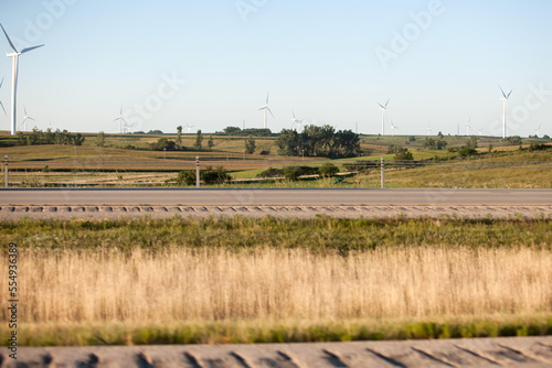 Windmill turbines cover open land alongside Interstate 80 in Iowa.; Des Moines, Iowa photo
