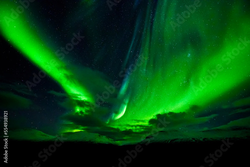 Bright green aurora borealis swoops across the night sky; Iceland photo