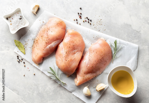 Obraz na plátně Raw chicken breast with spices on a light background top view