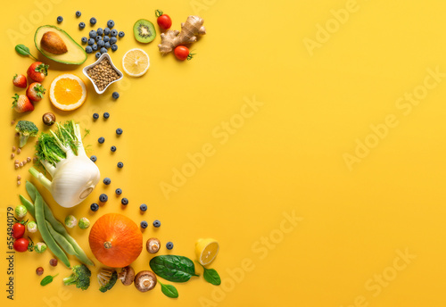 Fototapeta Naklejka Na Ścianę i Meble -  Set of various vegetables, fruits and berries for healthy and diet food on a yellow background with copy space top view