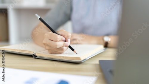 Asian woman taking notes in notebook while studying online in laptop at home, Video chat, Online communication , Stay home, New normal, Distance learning.., Social distancing, Learn online...