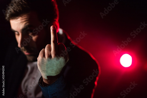 Quadro em tela Close up photo of man showing middle finger on pink and black background