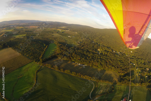 Hang gliding over the landing field near High Rock in the Cumberland Valley.; Cumberland Valley, Maryland. photo