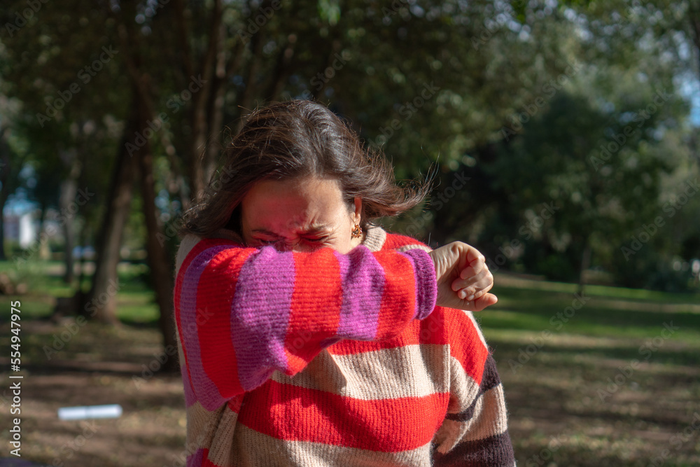 woman outside sneezing. cold, allergy concept woman outside sneezing. cold, allergy concept
