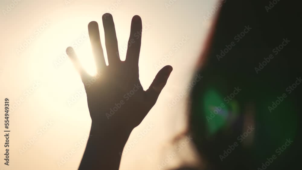Hand of happy girl at sunset. Sunset between hands of girl. Happy girl with long hair dreamily stretches out her hand to sun. Child's dream hand to sun. happy family concept.Religion and faith concept Hand of happy girl at sunset. Sunset between hands of girl. Happy girl with long hair dreamily stretches out her hand to sun. Child's dream hand to sun. happy family concept.Religion and faith concept