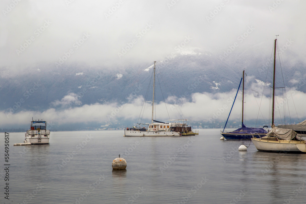 Amazing Foggy landscape of Boat and sailboats, anchored      on lake Maggiore -  view  from Locarno