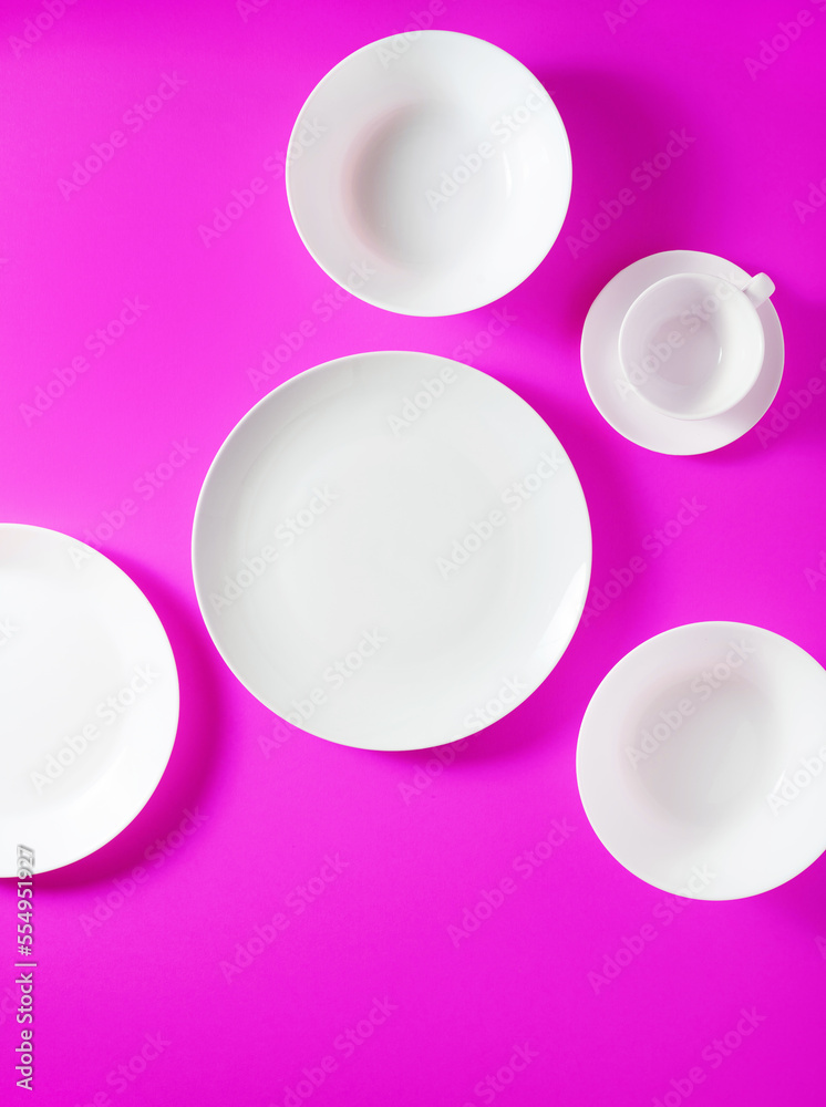 a set of white dishes on a bright violet background. taken from above a set of white dishes on a bright violet background. taken from above