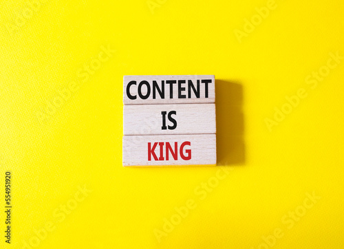 Content is king symbol. Concept words Content is king on wooden blocks. Beautiful yellow background. Business and Content is king concept. Copy space.