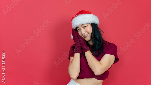 Young beautiful woman wearing Christmas Santa hat over isolated red background sleeping tired dreaming and posing with hands together while smiling with open eyes.