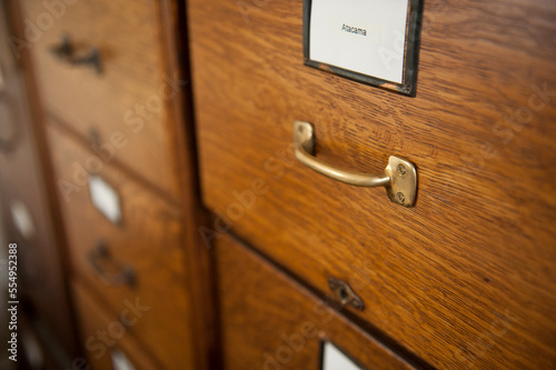 Close up of the wooden drawers, metal handle and label on a file cabinet; Lincoln, Nebraska, United States of America