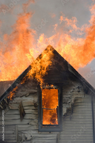 Local firefighters use a controlled burning of a house for practice.; Palmyra, Nebraska, United States of America