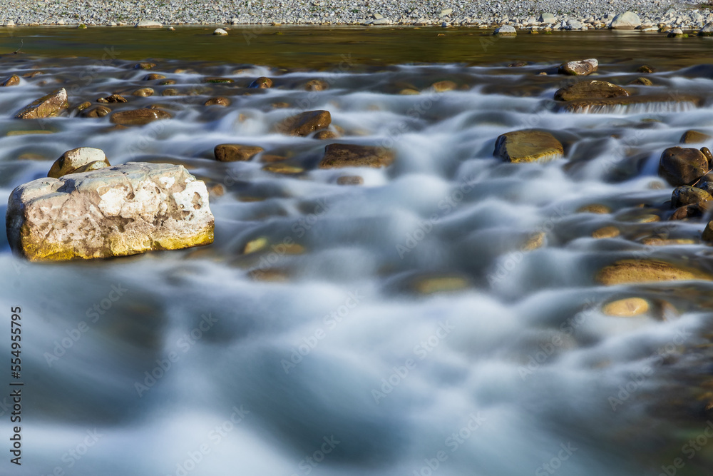 Long exposure time. A long exposition of the river in the Caucasus mountains. Long exposure on the river. The stones in the river are blurred from long exposure.. Long exposure time. A long exposition of the river in the Caucasus mountains. Long exposure on the river. The stones in the river are blurred from long exposure..