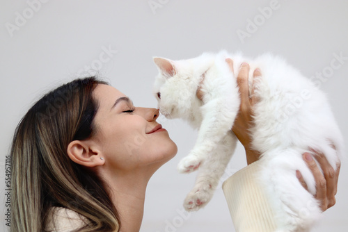 Fotografie Young happy smiling woman holding cute white Persian cat and lift up her cat, tr