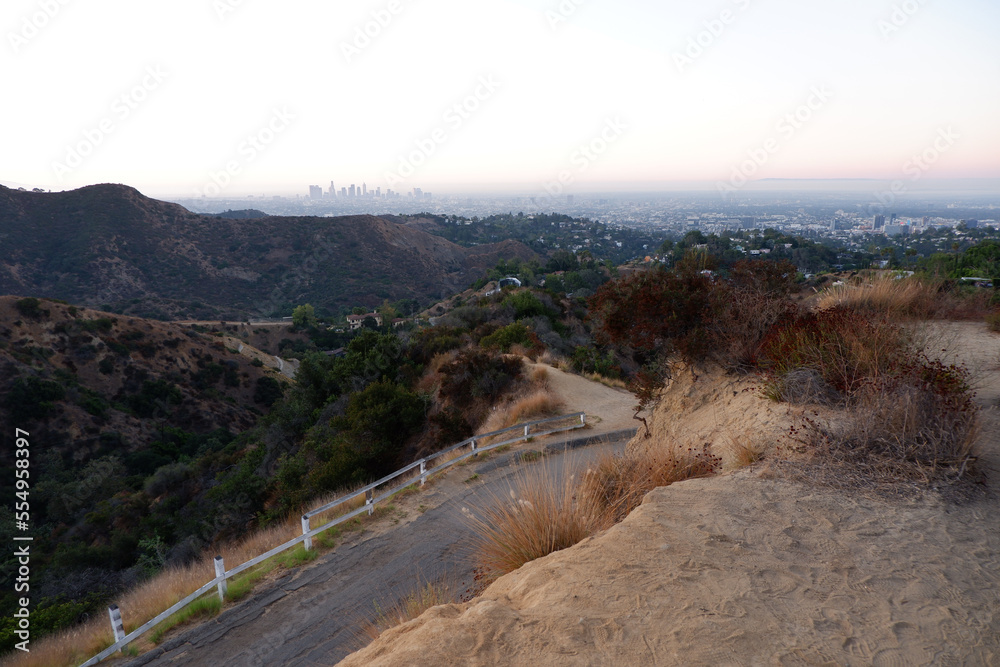 Beautiful landscape view on a road in Hollywood hills with Los Angeles on the horizon at sunrise