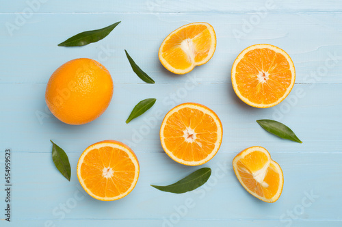 Flat lay with fresh oranges and leaves on wooden background