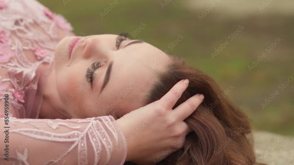 Portrait of mysterious woman enjoying nature outdoors. Amazing brunette girl touches her long hair. A joyful, dreamy and thoughtful look, a feeling of freedom. Ukrainian girl in a pink dress. Portrait of mysterious woman enjoying nature outdoors. Amazing brunette girl touches her long hair. A joyful, dreamy and thoughtful look, a feeling of freedom. Ukrainian girl in a pink dress.