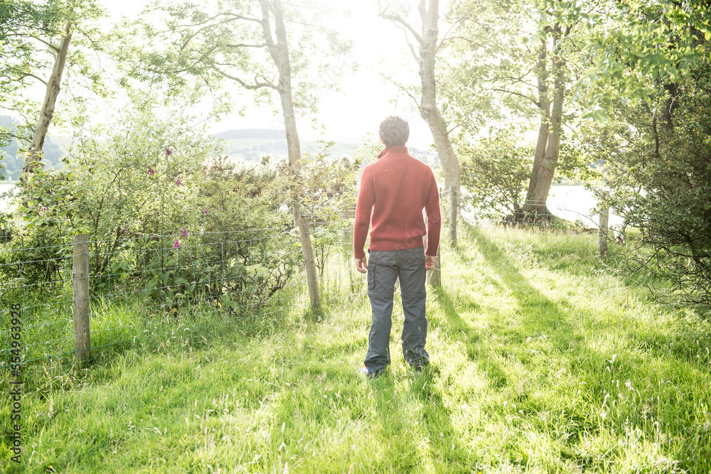 A bearded man in a red jumper standing on the shore of Bala Lake in Wales. A bearded man in a red jumper standing on the shore of Bala Lake in Wales.
