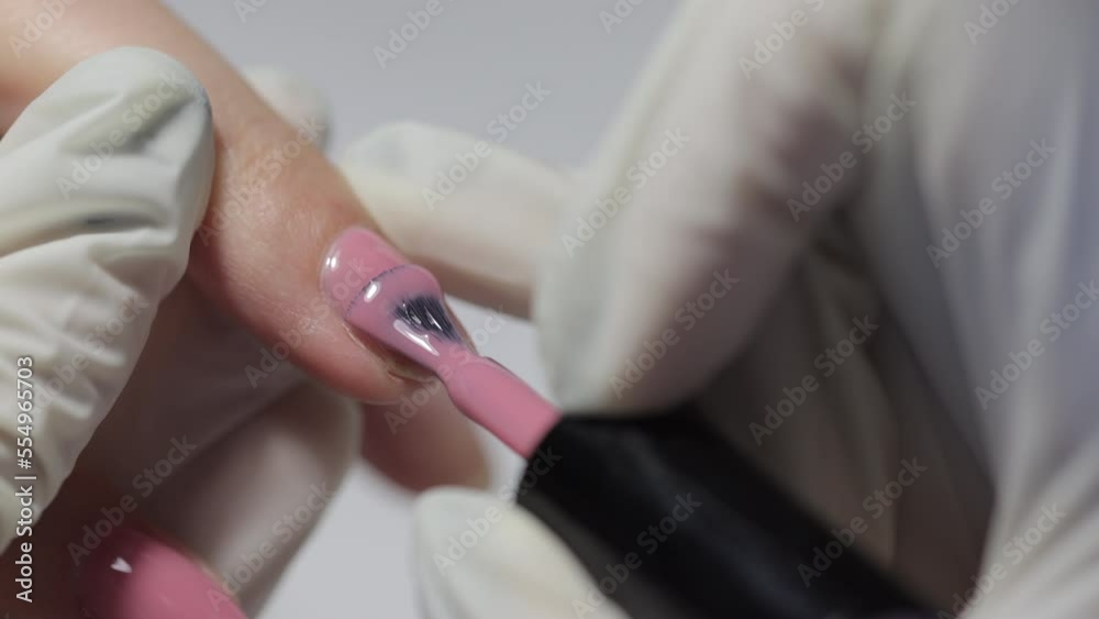 woman in nail salon does manicure. hand and nail care, shellac coating. nail service master in beauty salon makes manicurist to client, pink lacquer woman in nail salon does manicure. hand and nail care, shellac coating. nail service master in beauty salon makes manicurist to client, pink lacquer