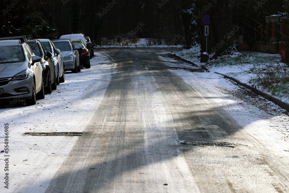 Zaśnieżona droga w mieście uwaga ślizgo na jezdni po opadach śniegu.  - obrazy, fototapety, plakaty 