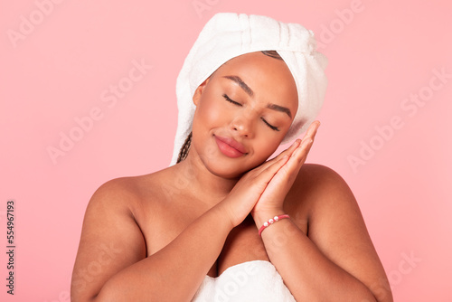 Beauty sleep concept. Portrait of black body positive lady napping, pretending sleeping over pink studio background