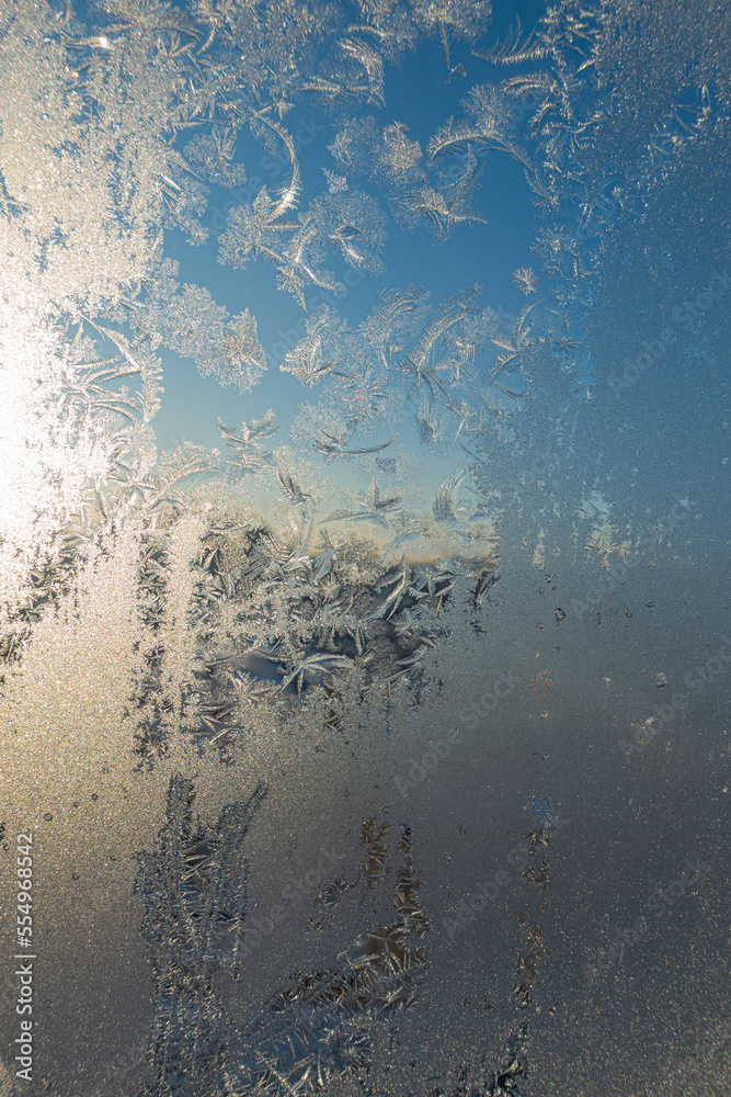 Frozen surface with icy pattern on window glass in cold winter day Frozen surface with icy pattern on window glass in cold winter day