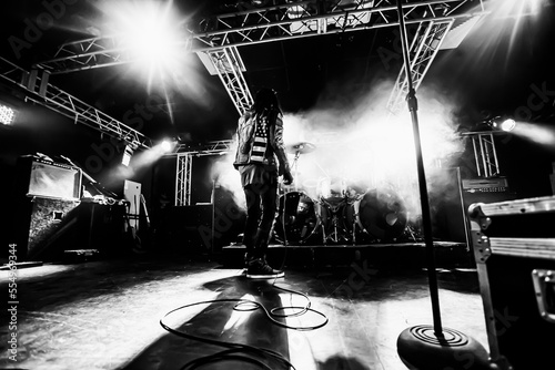 Musician on stage during a live concert. The punk bands vocalist walks the stage during the show.