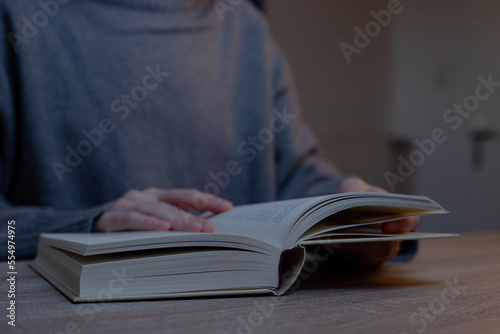 Woman reading sitting at desk.