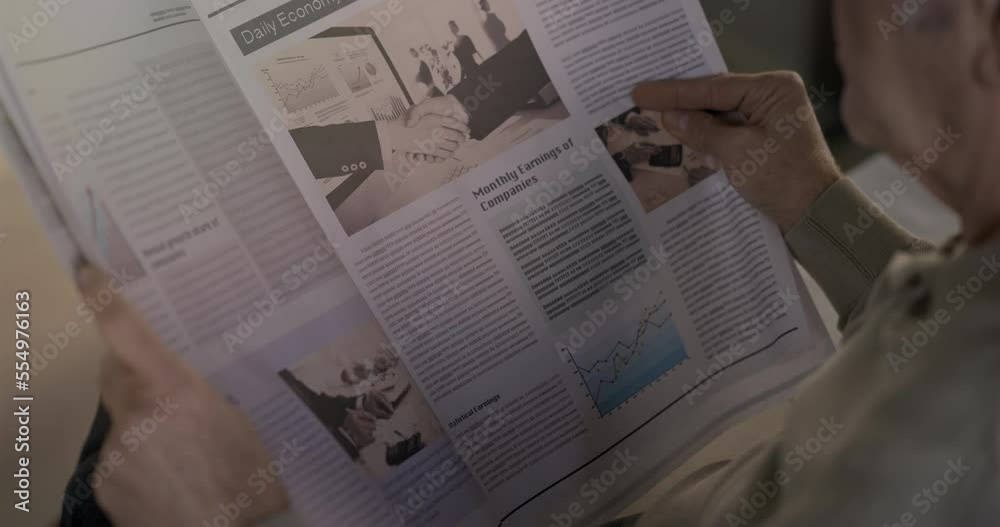 Old man reading the newspaper at home