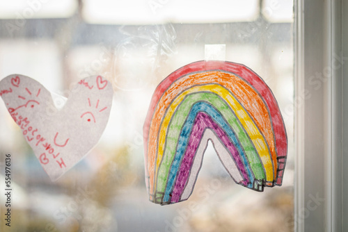 A window with a child drawing of a rainbow on it during lockdown. photo