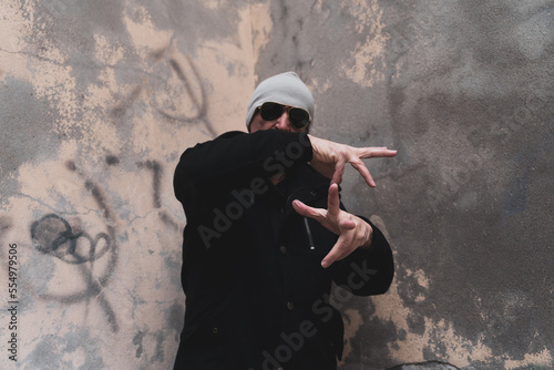 mature man rap singer posing in the street on the outskirts of a city photo