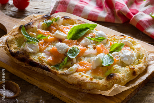 Pizza with salmon and cheese with basil on Roman dough, pinsa