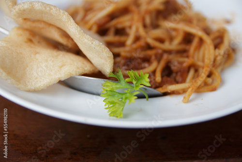 a green vegetable on white plate against spaghetti blur background