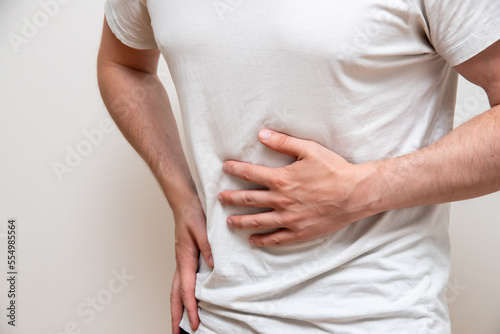 Wallpaper Mural Man in white shirt holding his stomack out of pain. Torontodigital.ca