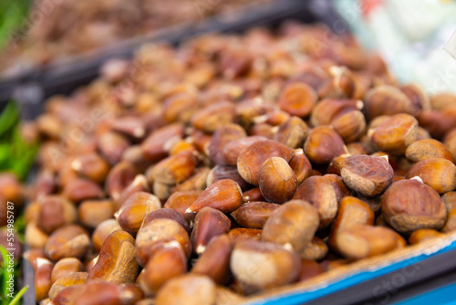 Close-up view of abundance of chestnuts in crate. Edible nut for sale at market.