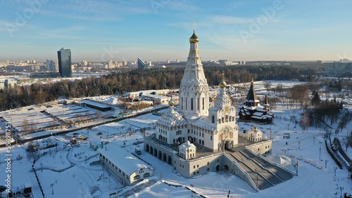 A huge Orthodox Christian church covered with a layer of white snow with golden domes in winter. The main Orthodox church in Minsk. Russian Orthodox Church.